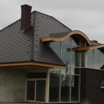 Projekt Filip — nowoczesny dom z wolem okiem i ciemną dachówką, widok frontalny