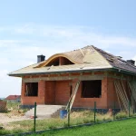 Dom ceglany z wolem okiem — widok boczny podczas budowy dachu