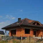 Ukończony dom z ciemną dachówką i wolem okiem — gotowa realizacja