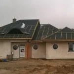 Dom ceglany z ukończonym wolem okiem przed ułożeniem dachówki dachówki — efekt końcowy