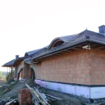 Dwa wole oka na domu Henryk — łukowe wole oko drewniane w trakcie budowy