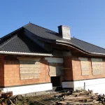 Ukończony dach z ciemną dachówką ceramiczną i wolem okiem