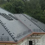 Dach pokryty szarą dachówką karpiówką z oknami dachowymi — detale wykończenia — firma Wole Oko