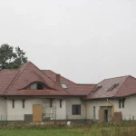 Wole oko i podniesienie połaci w projekcie Kora — brązowa karpiówka, budynek w budowie — firma Wole Oko